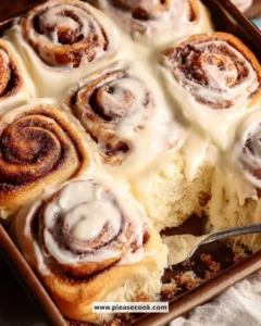 Delicious cinnamon rolls with icing on a wooden table