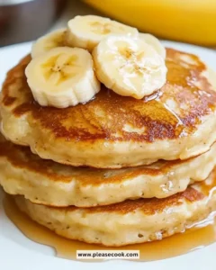 Plate of fluffy brown sugar banana pancakes topped with sliced bananas