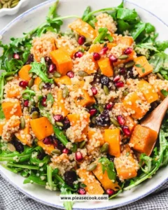 Colorful butternut squash and quinoa salad topped with fresh herbs and dressing