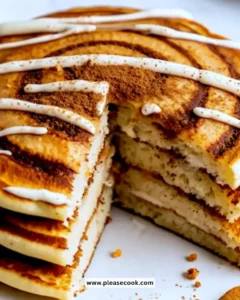 Delicious cinnamon roll pancakes topped with cinnamon butter and swirls.