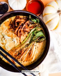 Bowl of dairy-free pumpkin ramen topped with mushrooms and herbs