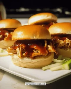 Easy BBQ chicken sliders on a platter with fresh toppings and sauces.