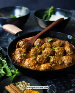 Plate of spiced Indian lamb meatballs served with herbs and sauce