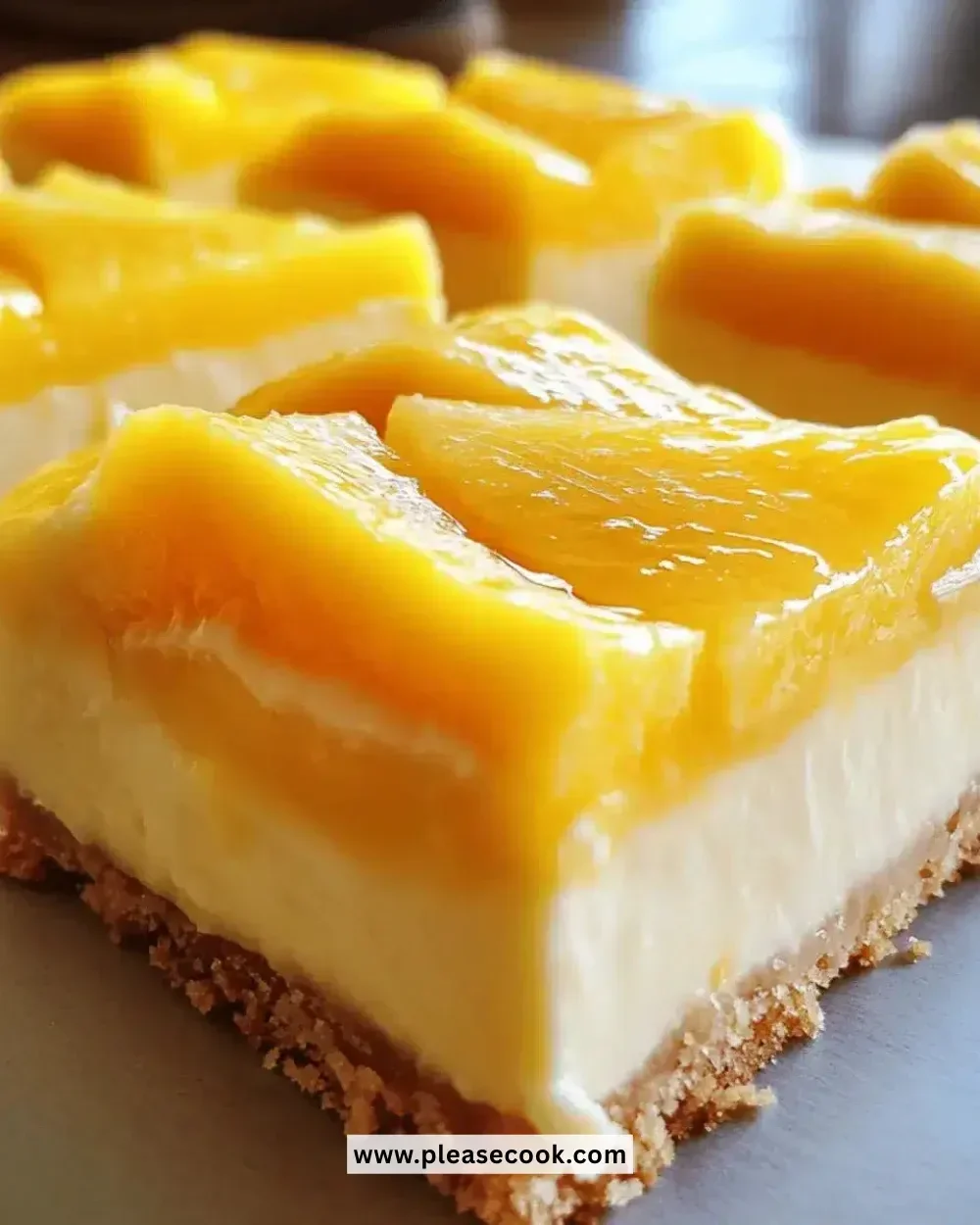 Delicious mango cheesecake bars topped with fresh mango slices.