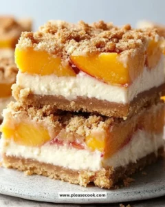 Delicious peach cobbler cheesecake bars topped with fresh peaches and a golden crust.