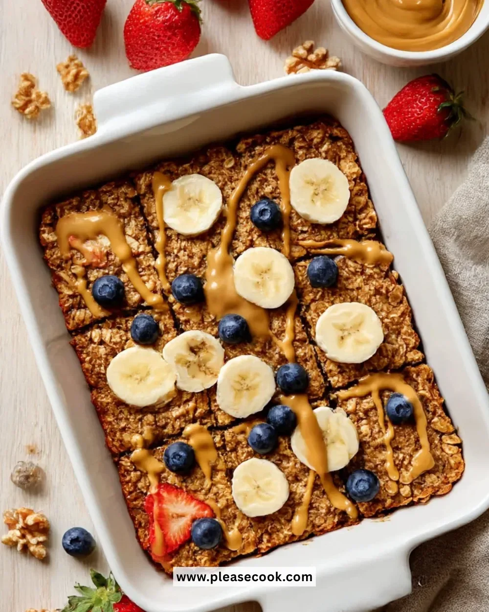 A bowl of banana baked oatmeal topped with sliced bananas and nuts.