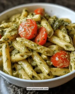 Served creamy pesto veggie pasta with fresh vegetables in a bowl.
