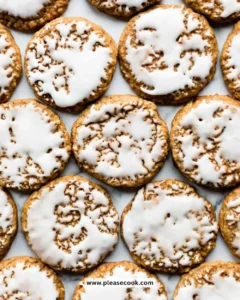 Delicious iced oatmeal cookies on a plate with a glass of milk