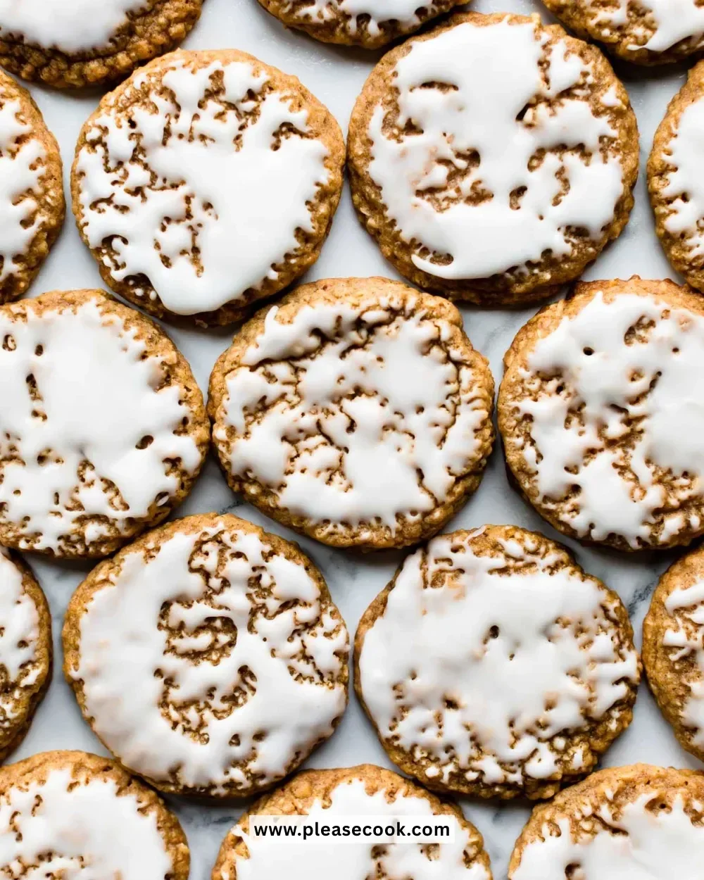 Delicious iced oatmeal cookies on a plate with a glass of milk