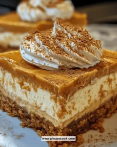 Delicious pumpkin spice cheesecake bars topped with whipped cream and cinnamon