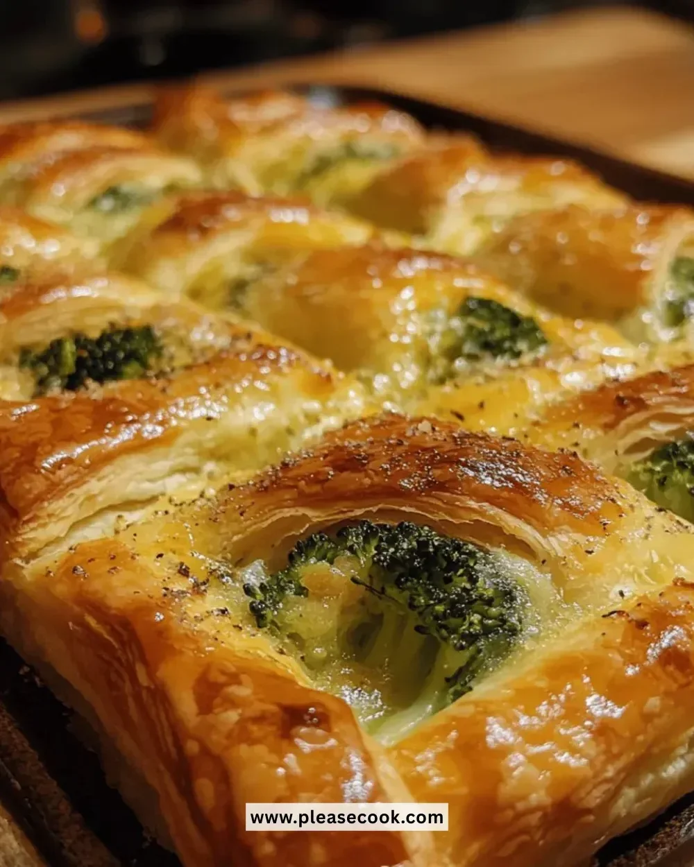 Cheesy broccoli puff pastry baked to a golden perfection, served on a plate.