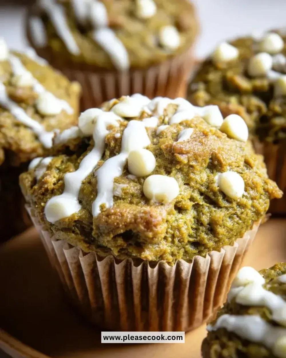 Matcha white chocolate pumpkin muffins on a wooden table