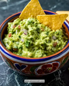 Freshly made perfect guacamole served in a bowl with tortilla chips
