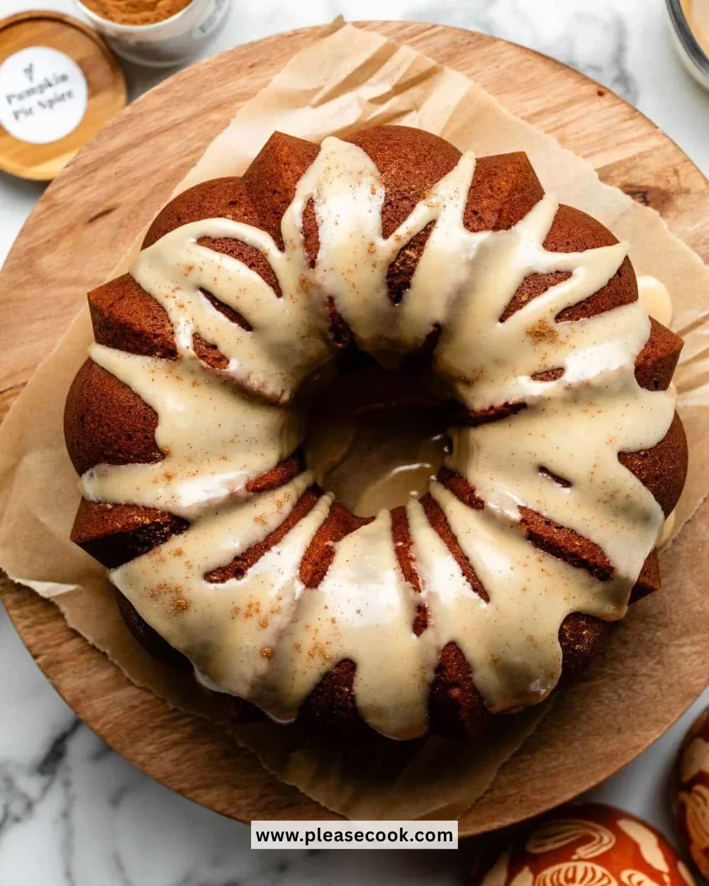 Delicious Pumpkin Bundt Cake topped with cream cheese icing on a white plate.