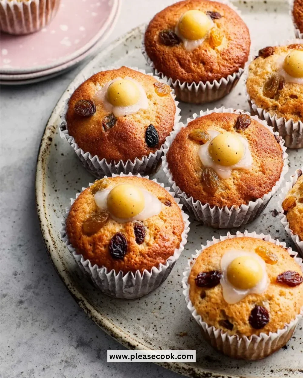 Close-up of freshly baked Simnel Muffins garnished with marzipan and dried fruits.