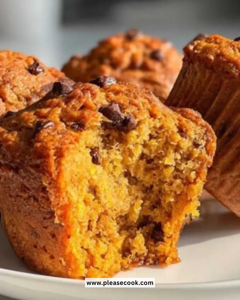 Freshly baked pumpkin chocolate chip muffins on a cooling rack.
