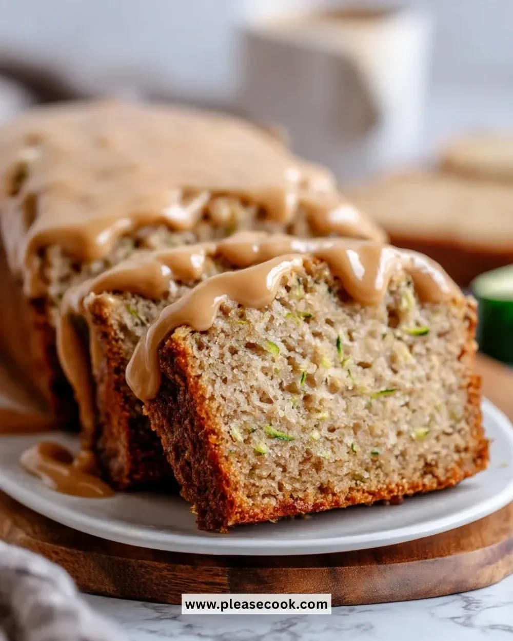 Slice of moist Apple Zucchini Bread with brown sugar frosting on a plate