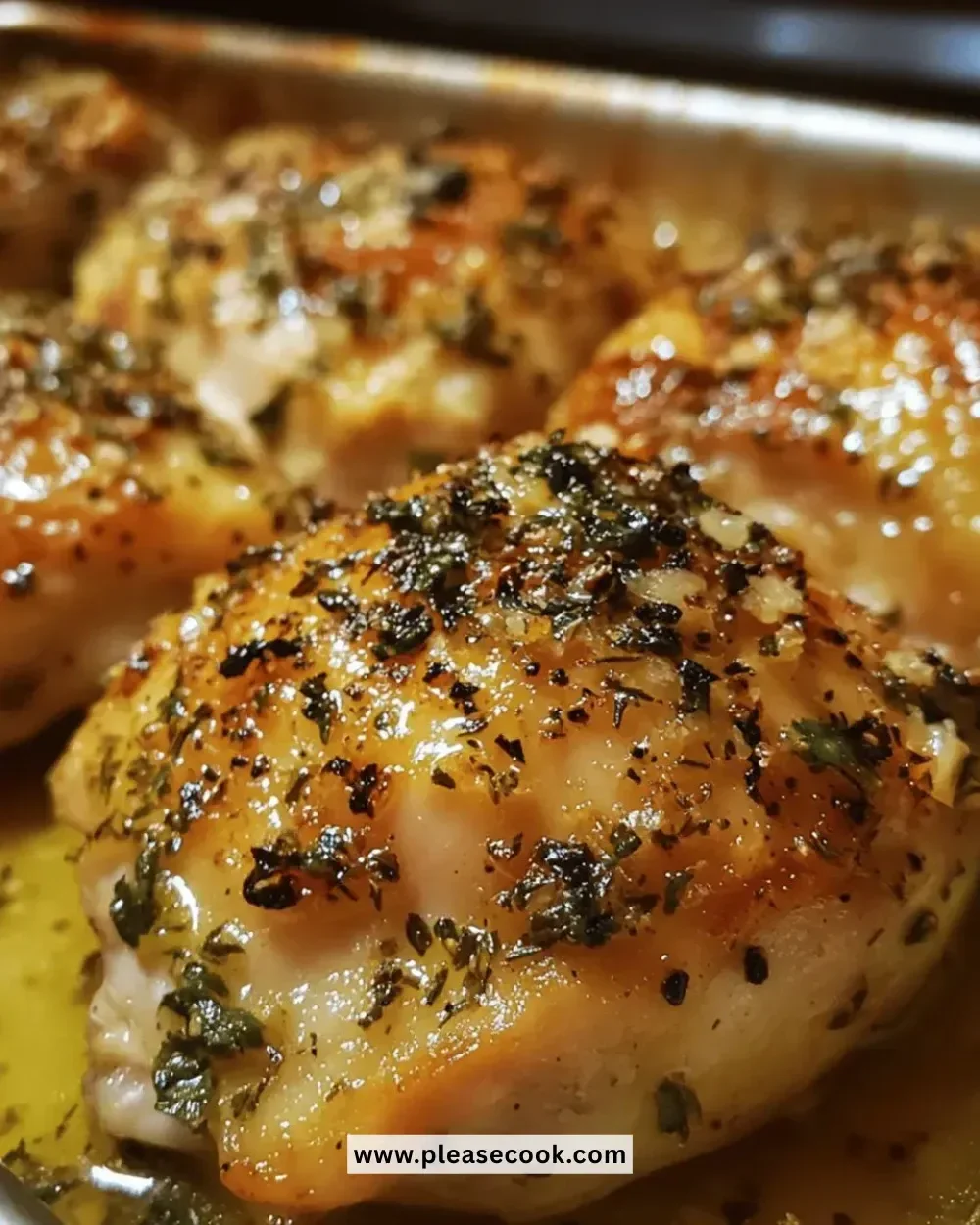 Juicy garlic herb roasted chicken thighs garnished with fresh herbs.