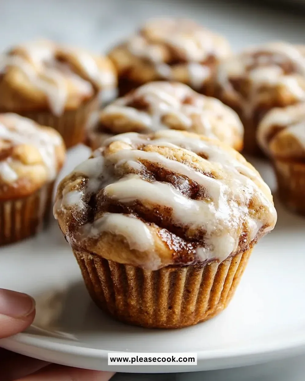 Delicious Cinnamon Roll Muffins topped with icing and cinnamon swirl