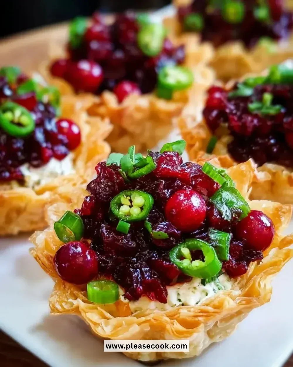 Cranberry Jalapeño Dip tarts garnished with fresh herbs