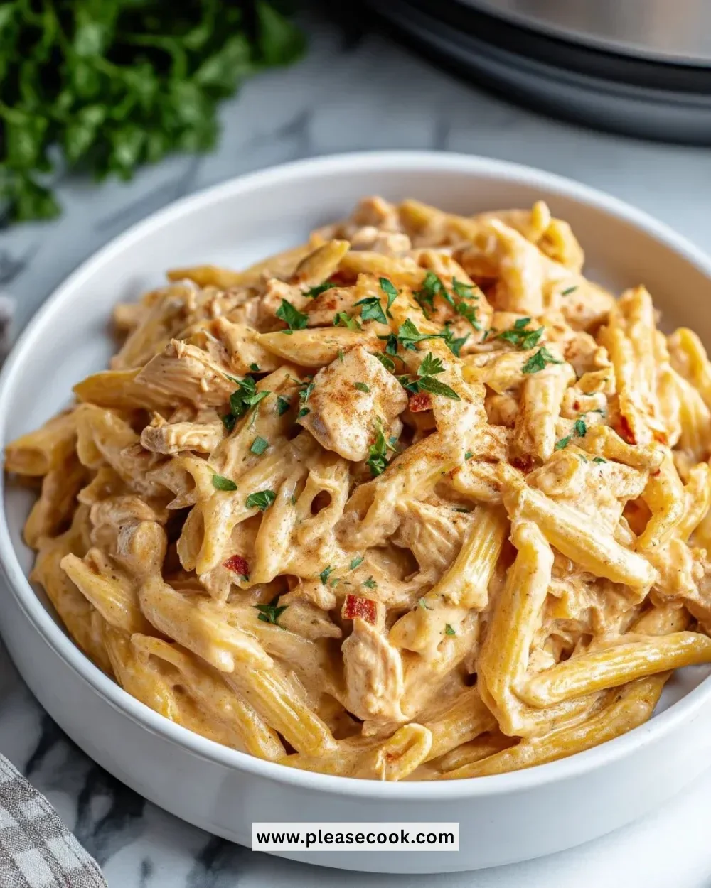 Crock Pot Creamy Cajun Chicken Pasta served in a bowl with herbs