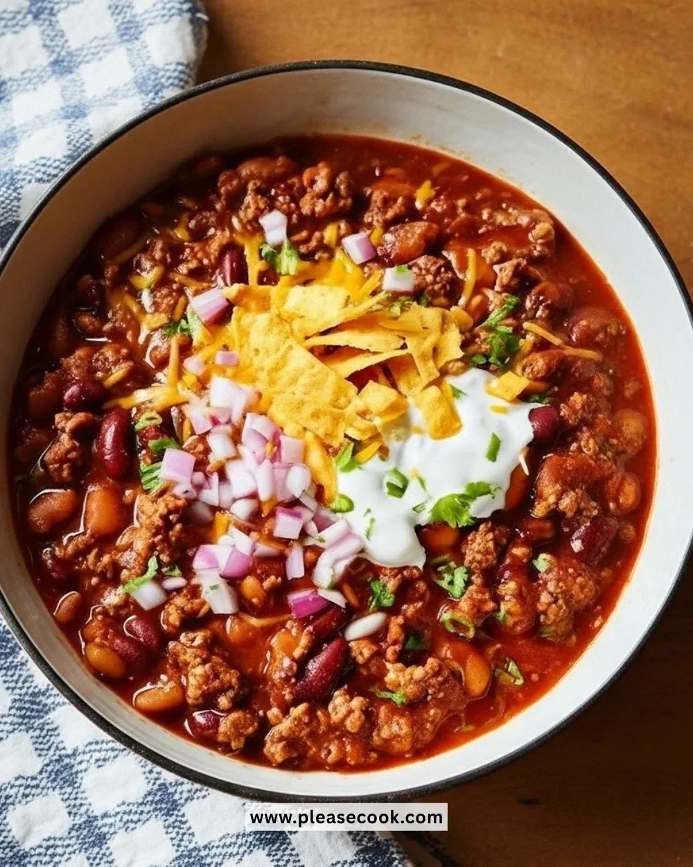 A bowl of hearty Pioneer Woman Chili with toppings, showcasing its rich texture