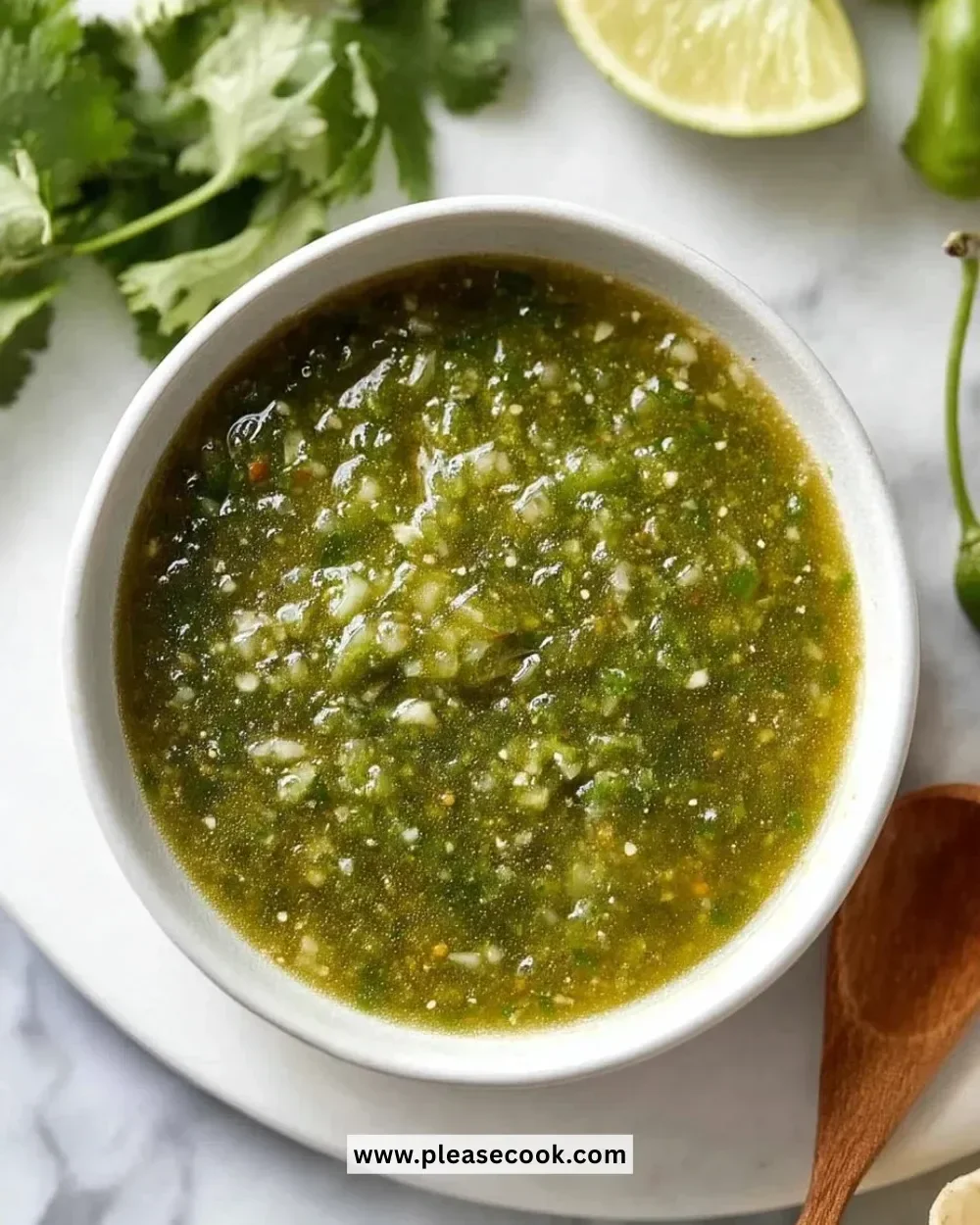 Homemade green sauce in a bowl, garnished with herbs and spices.