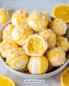 Delicious lemon cheesecake bites displayed on a white plate with fresh lemon slices.