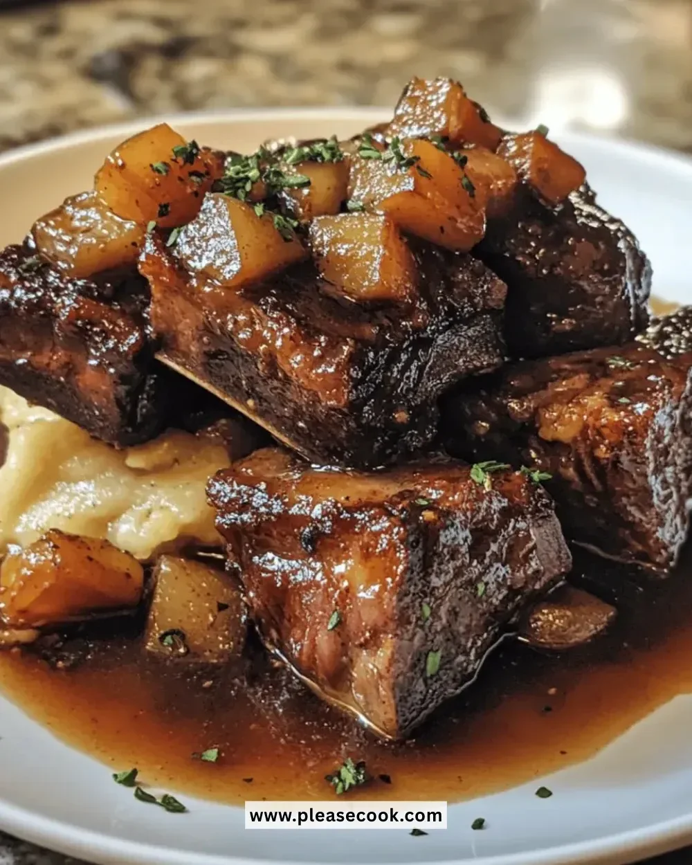Tasty apple-cider braised short ribs on a white plate garnished with herbs.
