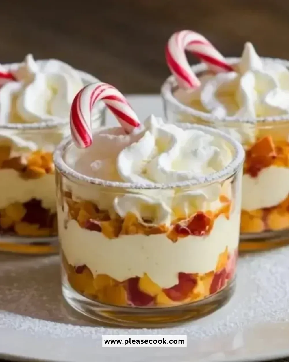 Mini Christmas Trifles dessert in festive glasses with whipped cream and berries
