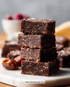 No Bake Vegan Date Brownies topped with nuts and coconut flakes