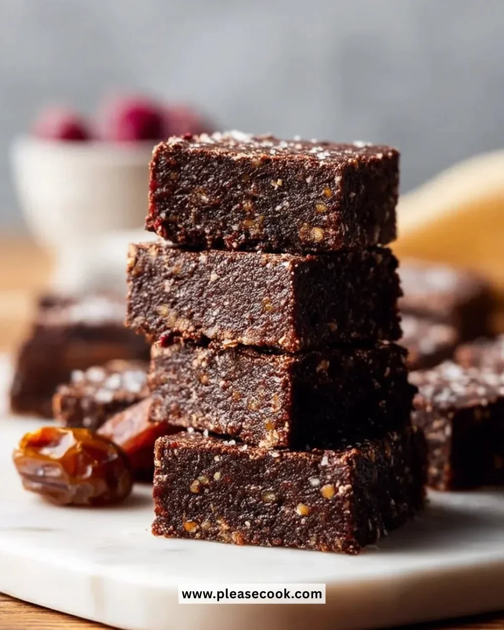 No Bake Vegan Date Brownies topped with nuts and coconut flakes