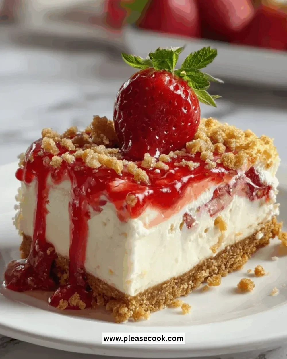 A delicious slice of strawberry crunch cheesecake topped with strawberries and crunchy crumbs.