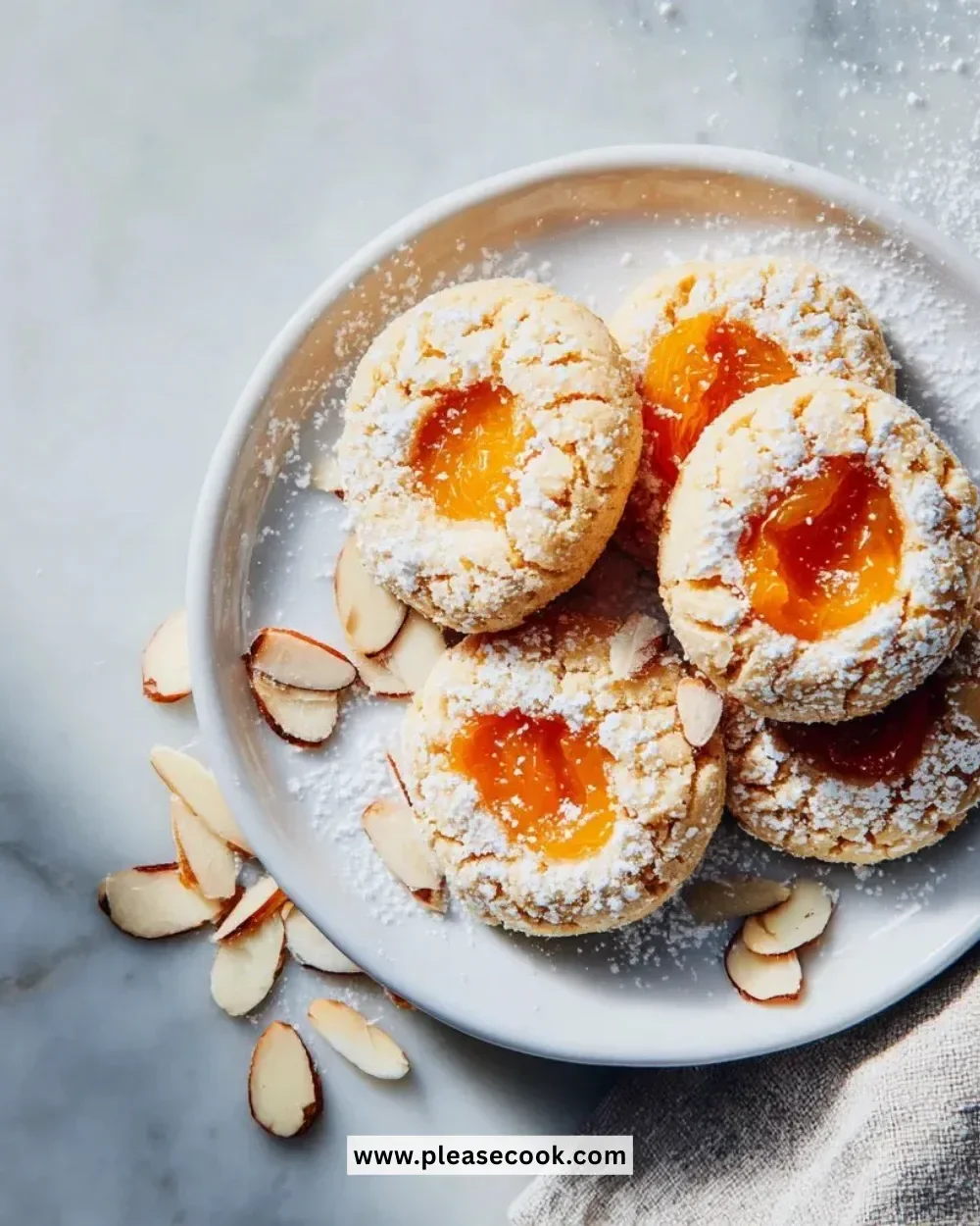 Delicious apricot almond thumbprint cookies arranged on a plate