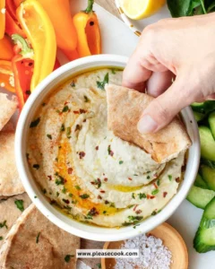 Baba Ganoush, a creamy eggplant dip served with pita bread and garnished with olive oil.