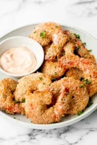 Plate of crispy baked coconut shrimp with dipping sauce