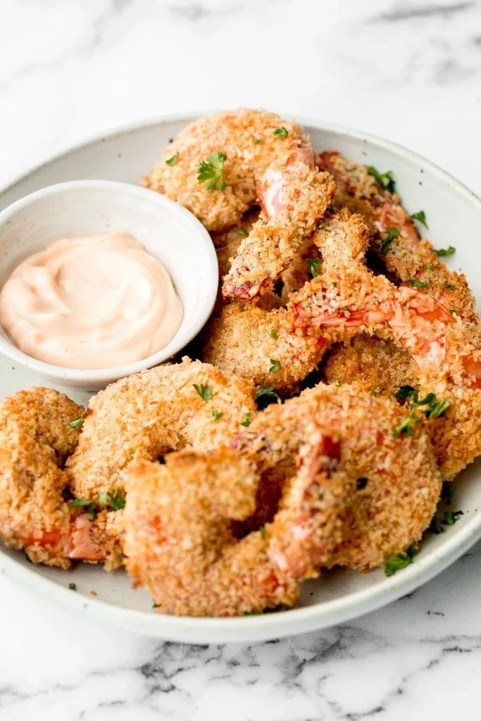 Plate of crispy baked coconut shrimp with dipping sauce