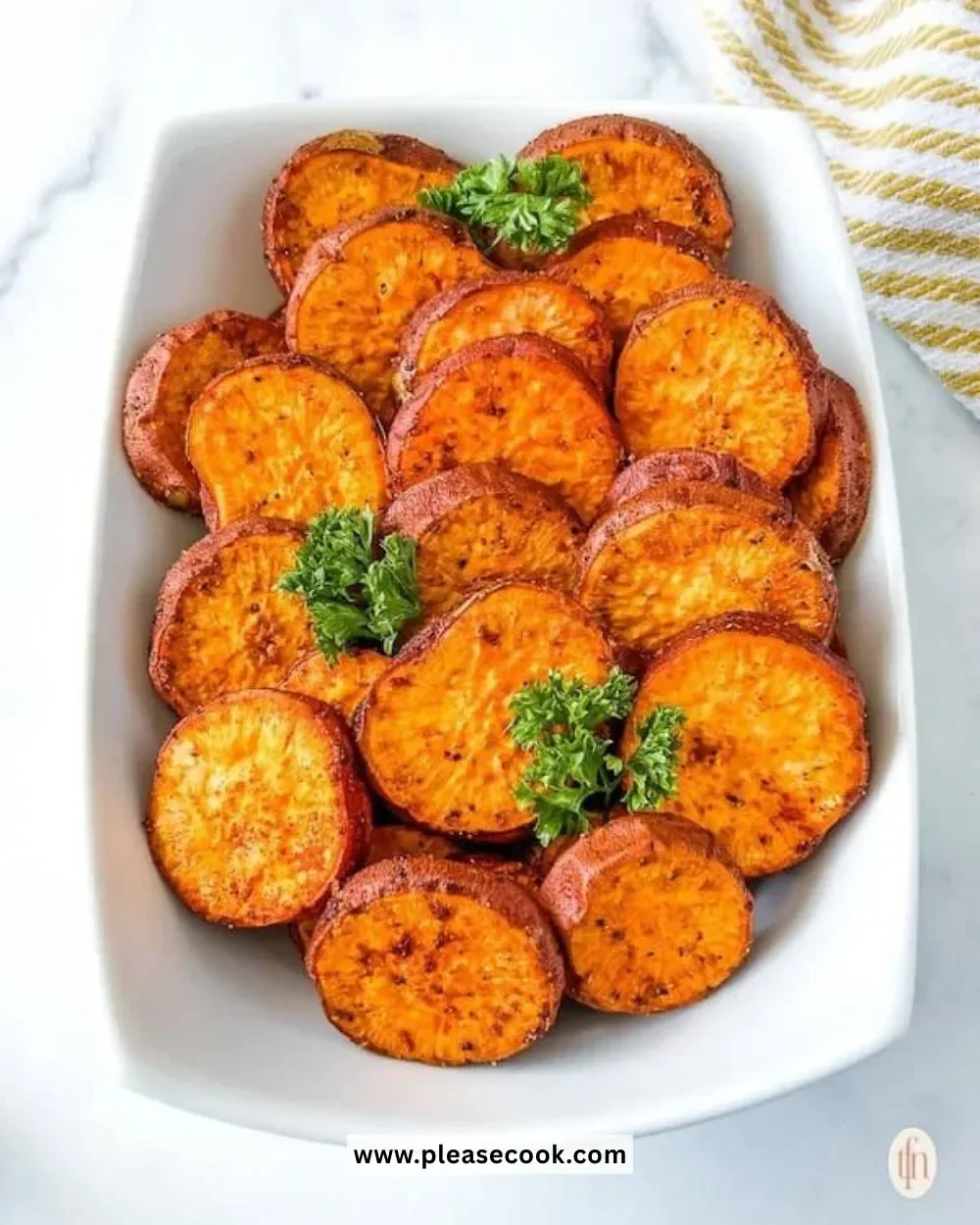 Baked sweet potato slices on a plate garnished with herbs