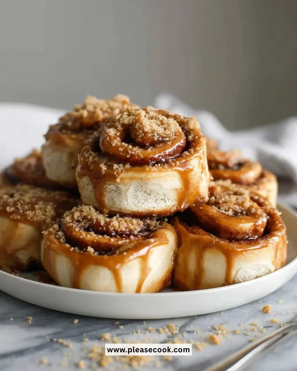 Biscoff cookie butter cinnamon rolls freshly baked and topped with icing.
