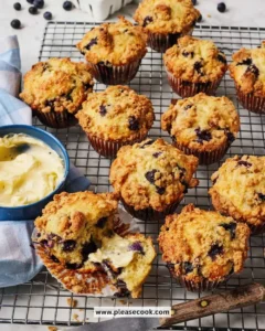 Freshly baked blueberry muffins with plump blueberries on a wooden table