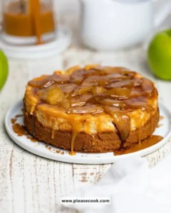 Slice of caramel apple cheesecake topped with caramel drizzle and apple slices