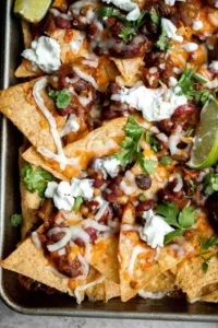 Delicious Chili Nachos topped with cheese, jalapeños, and fresh salsa served on a platter.