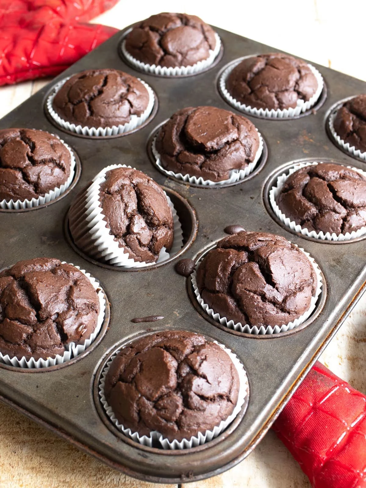 Delicious chocolate protein muffins stacked on a rustic wooden table
