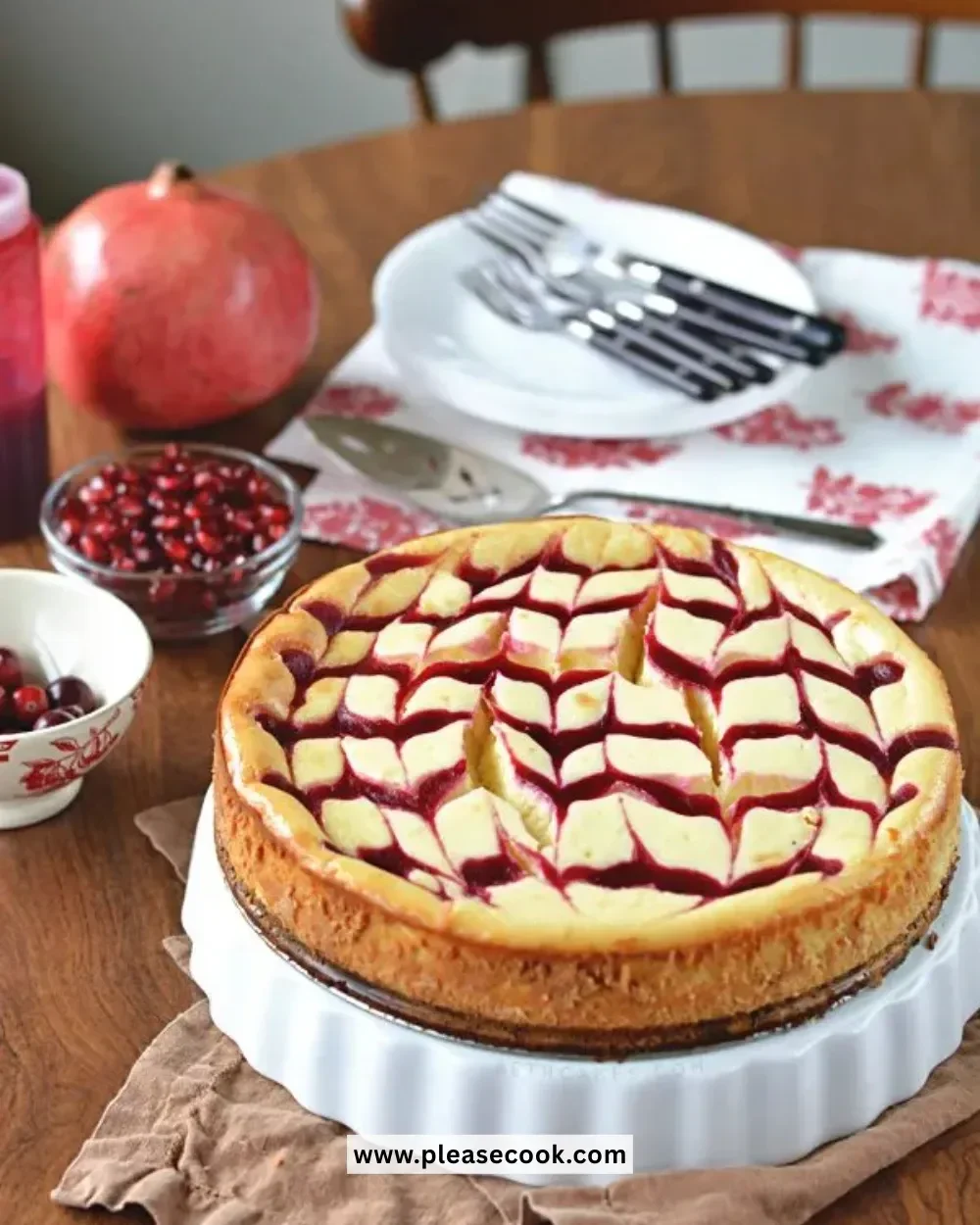 Cranberry-pomegranate swirled white chocolate cheesecake slice on a plate