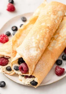 Plate of egg white protein crepes topped with fresh fruits