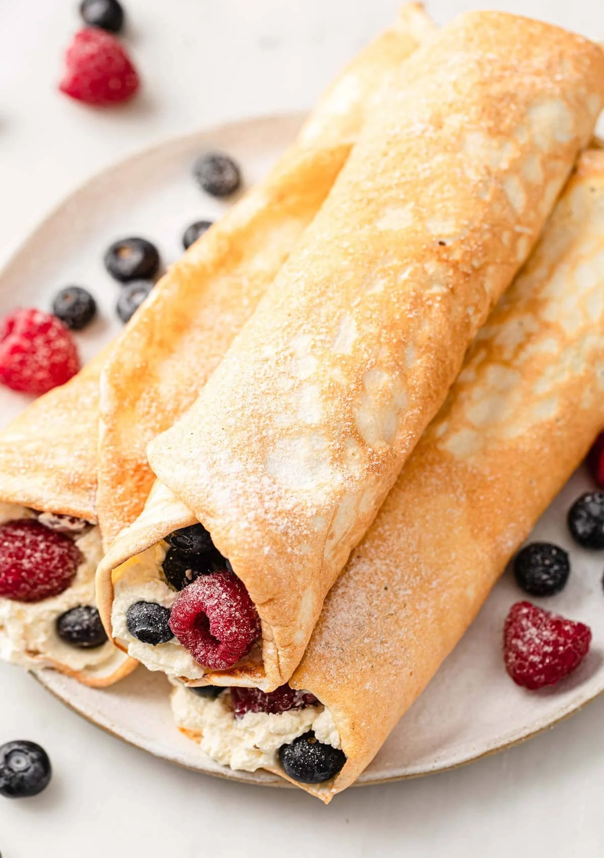 Plate of egg white protein crepes topped with fresh fruits