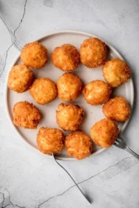 A plate of golden Fried Mac and Cheese Balls served with dipping sauce