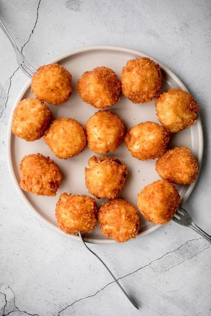 A plate of golden Fried Mac and Cheese Balls served with dipping sauce