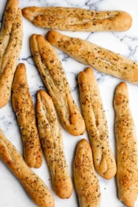 Golden-brown garlic breadsticks served with marinara sauce