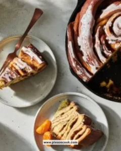 A giant cinnamon roll with icing on a plate, freshly baked and golden brown